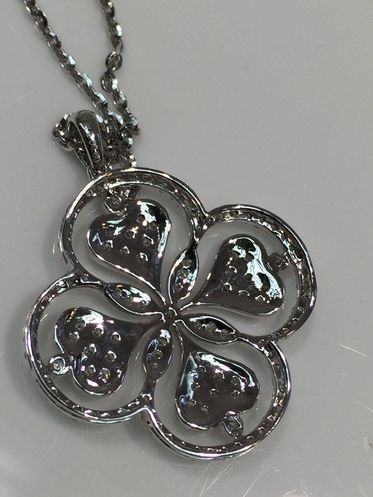 Beautiful Fancy Clover or Floral Design Diamond Pendant in 14K white gold with gem quality diamonds. Approximately F-Color, VS Clarity. Total Weight of .60 Carats of Diamonds. Lovely High Polished Back added to show attention to detail as well as style. White Gold Chain in 14 Karat Gold with Lobster Clasp included. Chain is of High Shine Cable Design. White Gold Flower-shaped Jewelry With Pave Setting, Diamond White Diamond Flower-shaped Jewelry, Diamond White Flower Shaped Platinum Jewelry, Diamond White Flower-shaped Diamond Jewelry, Elegant Platinum Flower Jewelry, Elegant Flower-shaped Platinum Jewelry, White Diamond Necklace With Flower Shape And Diamond Accents, White Diamond Necklace With Flower-shaped Accents, Diamond White Jewelry With Flower Shape And Diamond Accents