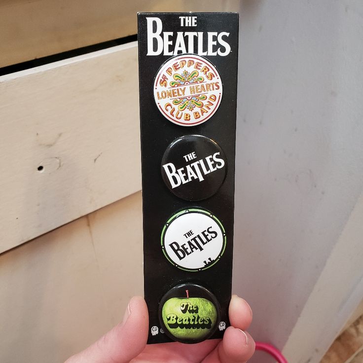 the beatles button set is in someone's hand