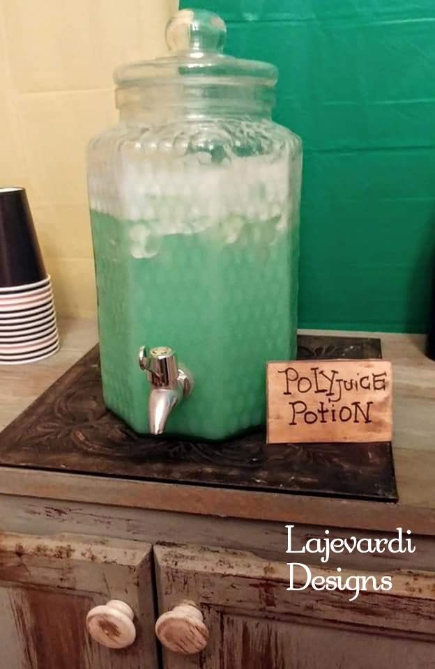 a large glass jar filled with liquid sitting on top of a wooden table next to a sign