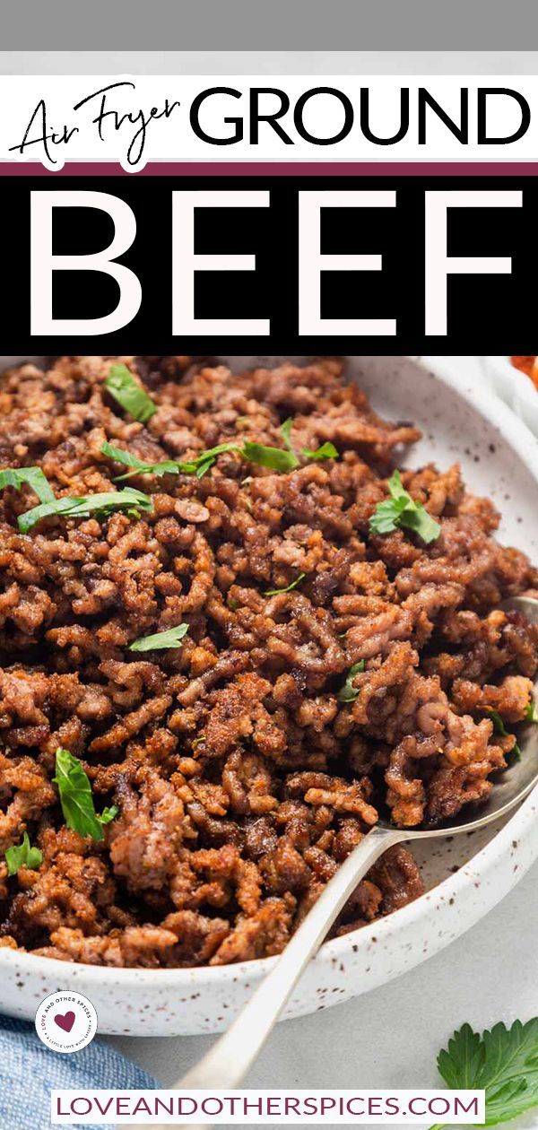 a bowl filled with ground beef and garnished with parsley on the side