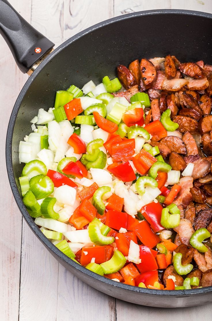 a skillet filled with chopped vegetables and meat