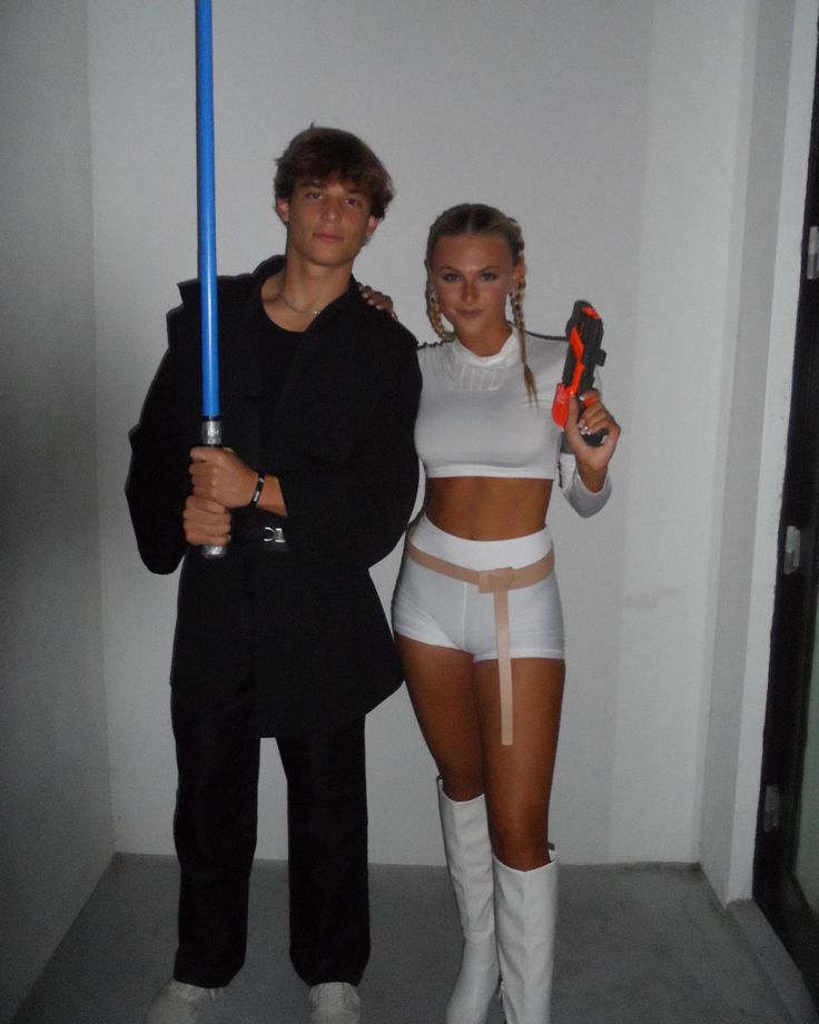 a man and woman dressed up as star wars characters holding lightsabens in their hands