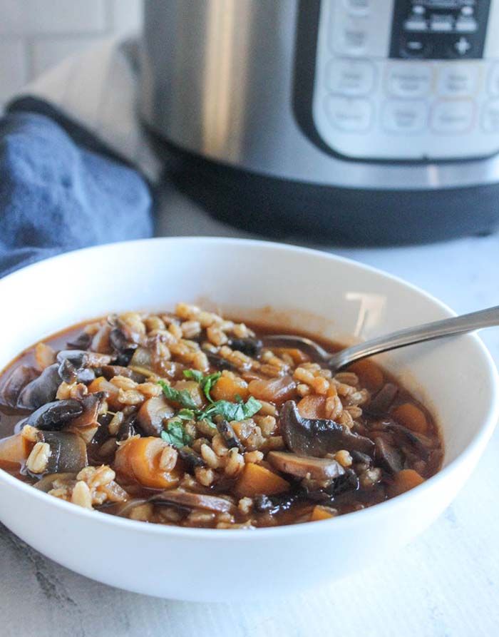 a white bowl filled with food next to an electric pressure cooker on top of a table