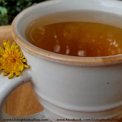 a white cup filled with tea next to a yellow flower