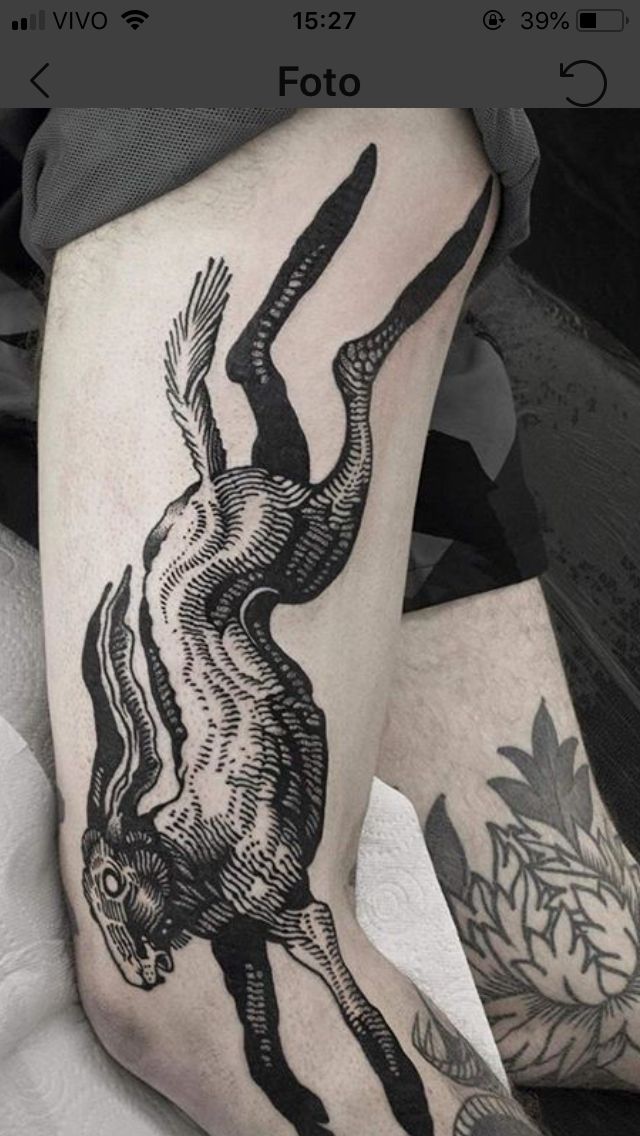 a black and white photo of a person's leg with an animal tattoo on it