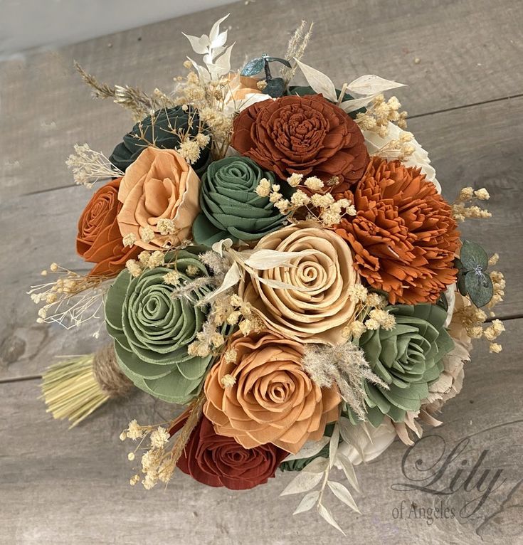 the bridal bouquet is made up of flowers and leaves, including an orange rose