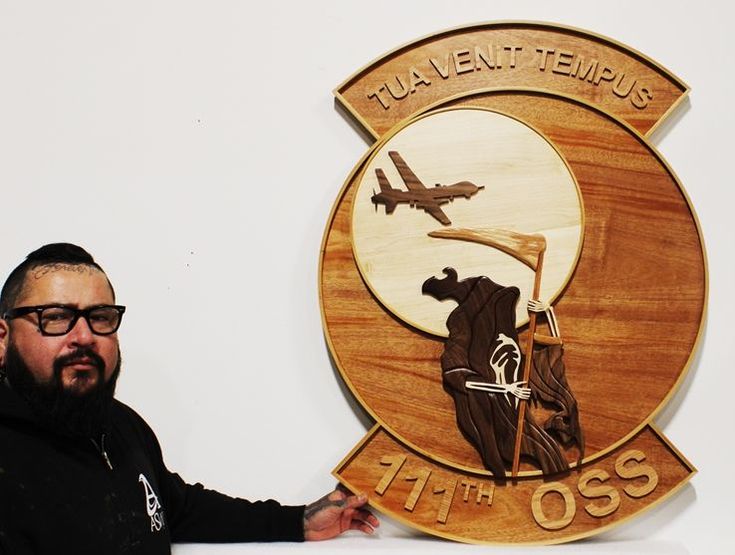 a man standing in front of a plaque with an airplane and the words tulevet - tempus on it