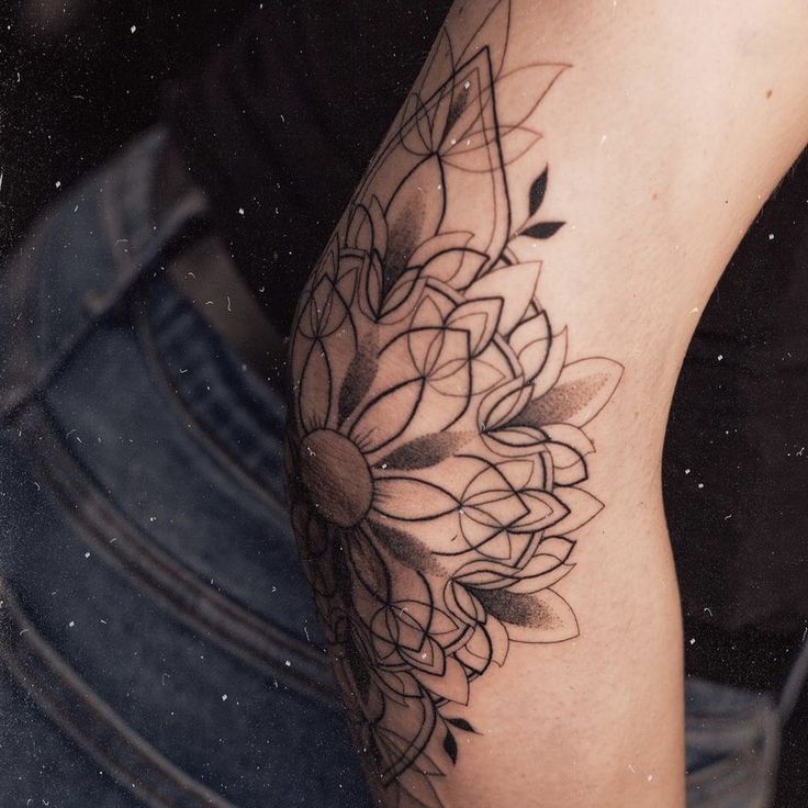 a woman's leg with a tattoo on it and flowers in the middle,