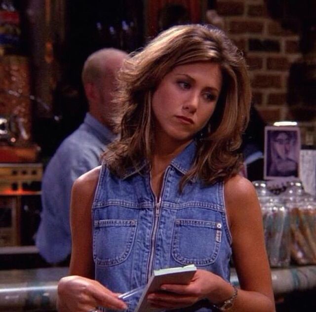 a woman standing in front of a bar holding a book