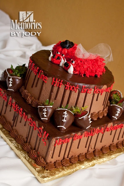 a three tiered chocolate cake decorated with strawberries and footballs on the top