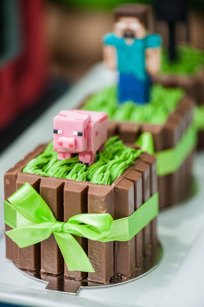 there are two cakes that look like farm animals in the grass with green bows on them