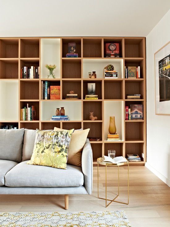 a couch sitting in front of a book shelf filled with books