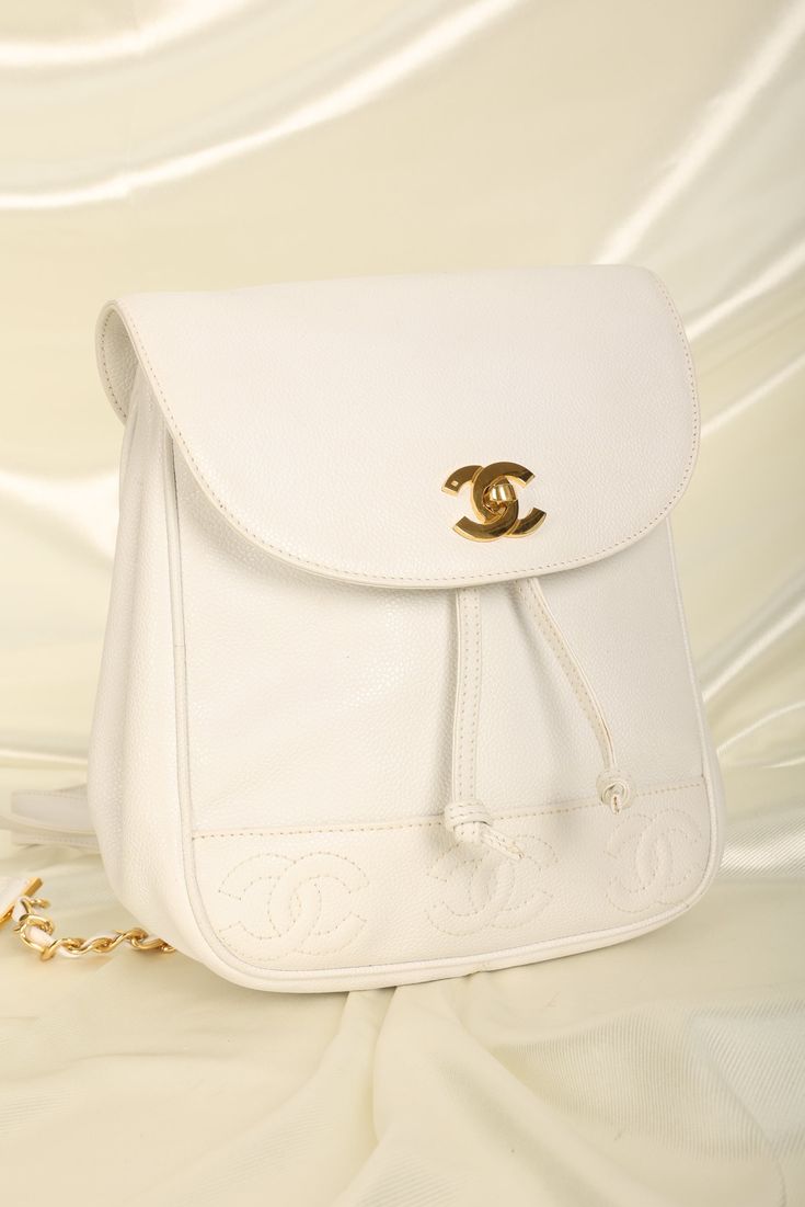 CONDITION: GOOD VINTAGE .??¨ Bringing to the shop a rare snow-white??¨Chanel caviar backpack with 24K plated gold hardware, and mini timeless logos on bottom of bag. Drawstring bucket for easy access. Perfect for festival season or travel! Spacious interior. 24K gold plated chain straps. Backpack currently going online for $3300-$6000. Crafted in 1994-1996 Please note: Minor glue reside along edges as shown in photos. Light hairline scratches on turnlock hardware. In order to meet the current demand and given the??¨nature of sourcing inventory, all sales are final. Please be sure to review all pictures and ask any questions prior to making a purchase! To prevent any form of fraud, I??¨keep video records of??¨myself??¨packaging??¨and dropping off each order, and??¨all??¨orders ship with??¨t Designer Backpack, Girl Backpacks School, Chanel Caviar, Bottega Veneta Shoulder Bag, Backpack Tote Bag, Designer Backpacks, Girl Backpacks, Gold Plated Chains, Prada Bag