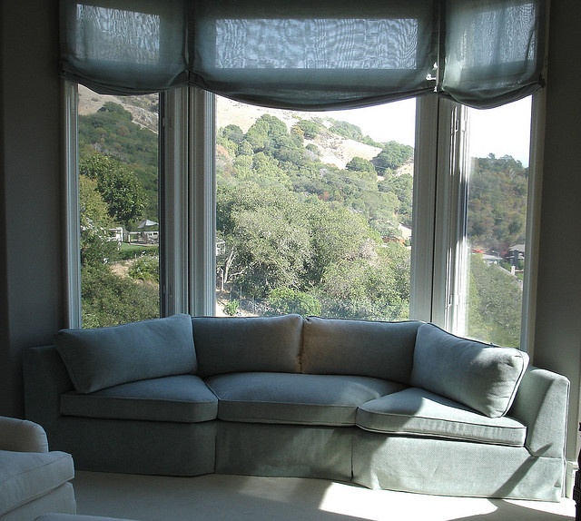 a couch sitting in front of two large windows