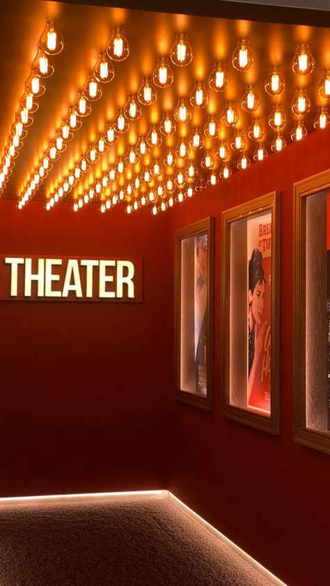 a red room with three movie posters on the wall and lights hanging from the ceiling