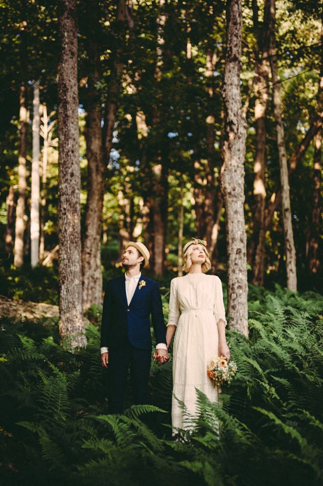 a man and woman standing next to each other in the woods