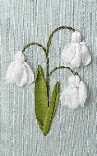 three white flowers with green stems on a light blue background, in the shape of a heart