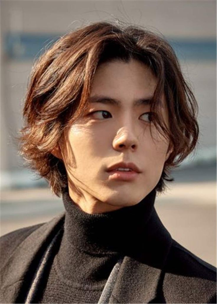 a young man in a black turtle neck sweater looking at the camera with an intense look on his face