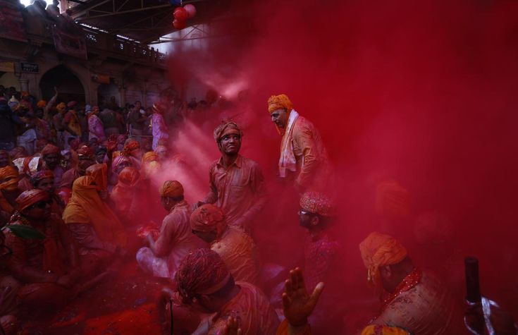 many people are covered in red and pink powder