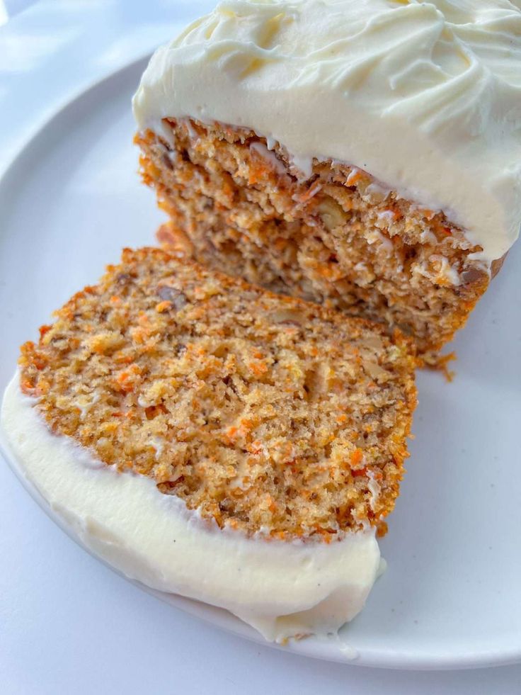 a piece of carrot cake with white frosting on a plate