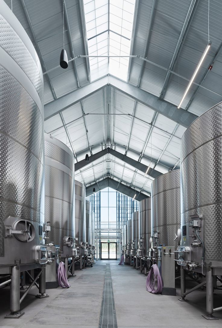 the inside of a large building with many metal tanks