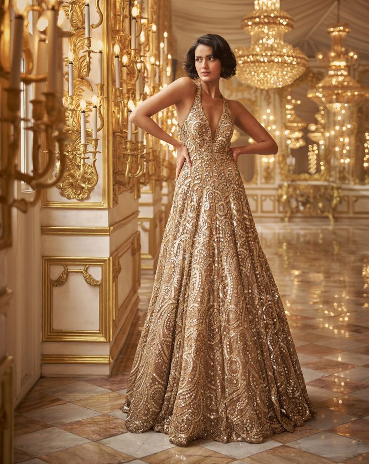 This gold gown features bold sequin embroidery and a criss cross back.From Seema Gujral's Inara collection. DELIVERY TIMEPlease allow 8-12 weeks for your outfit to arrive. FABRIC DETAILSNet Professional cleaning only. Lion King Wedding, Shaadi Outfits, Manish Malhotra Bridal, V Neck Gown, Gold Sequin Gown, Engagement Gown, Seema Gujral, Golden Gown, Net Gowns