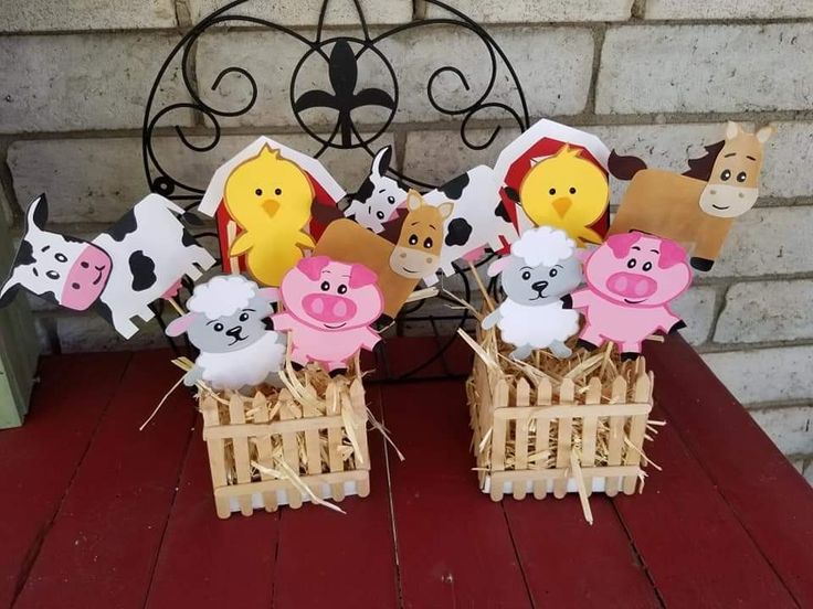 there are many farm animals in the basket on the table and one is cut out