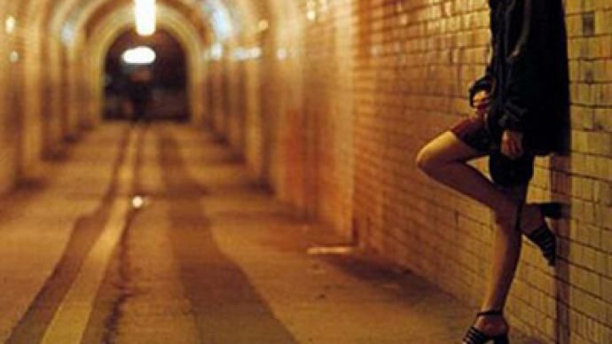 a woman standing in the middle of a tunnel with her leg up against the wall