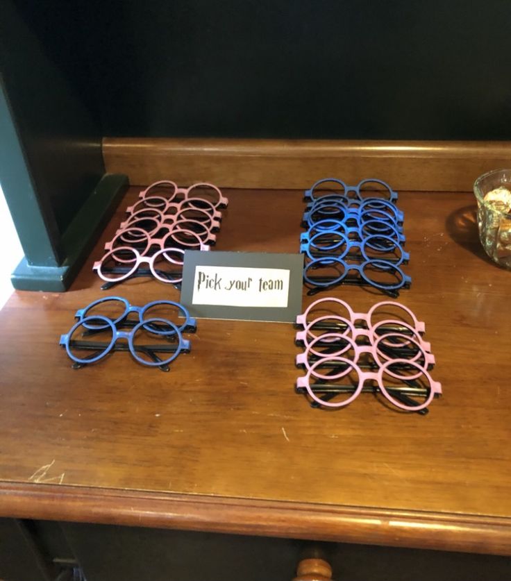 several pairs of pink and blue glasses sitting on top of a wooden table