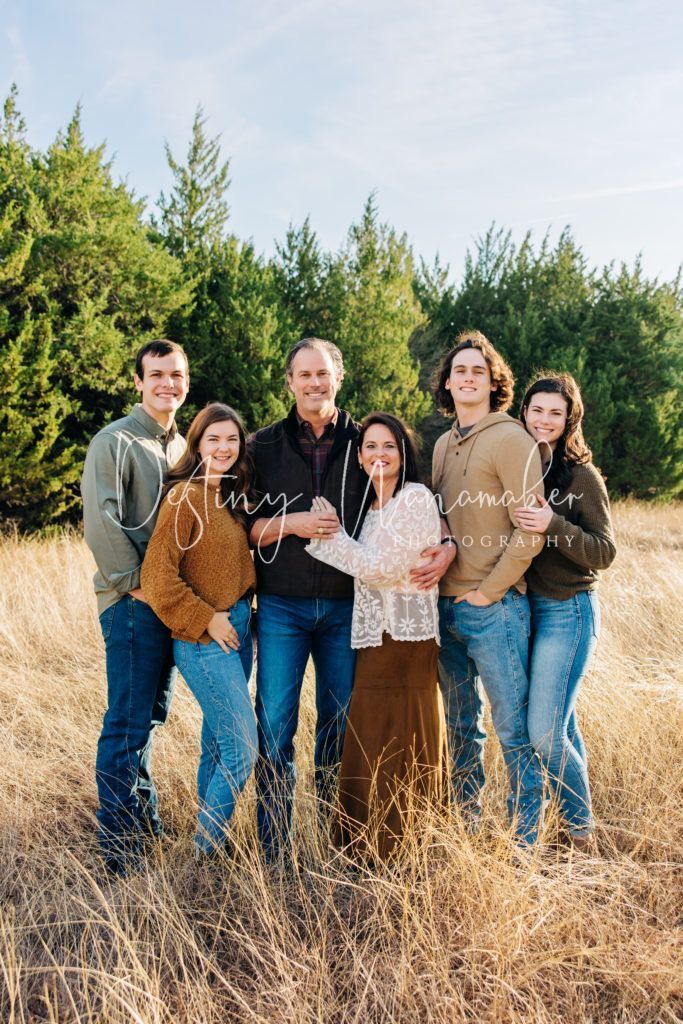 a family posing for a photo in the tall grass