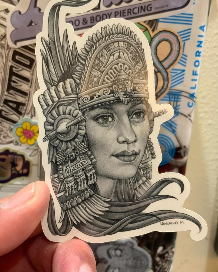 a person holding up a sticker with an image of a woman wearing a headdress