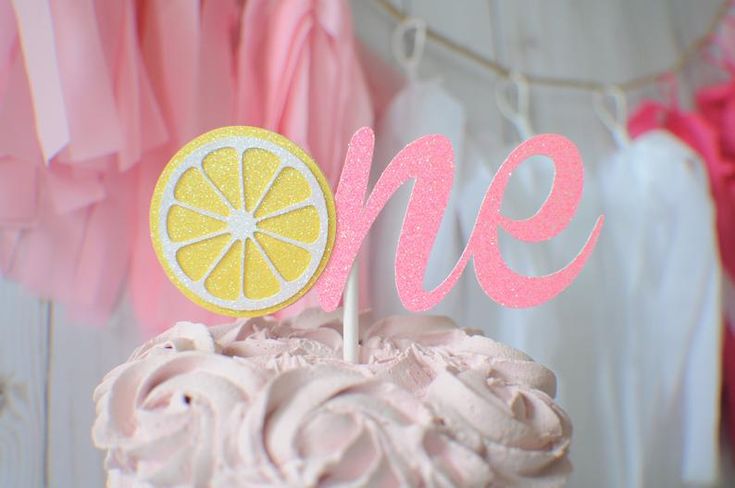 there is a pink cake with a lemon on top