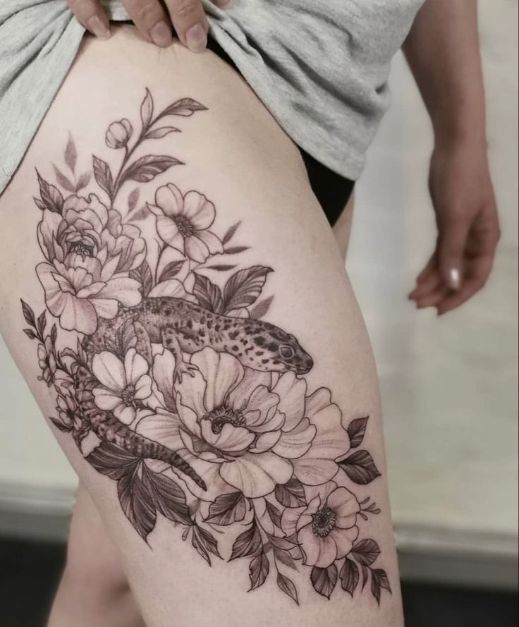 a woman's thigh with flowers on it and a butterfly sitting on the flower