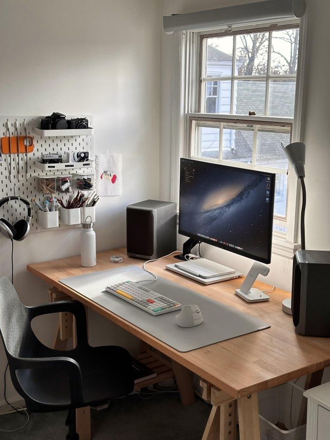 a desk with a computer and speakers on it