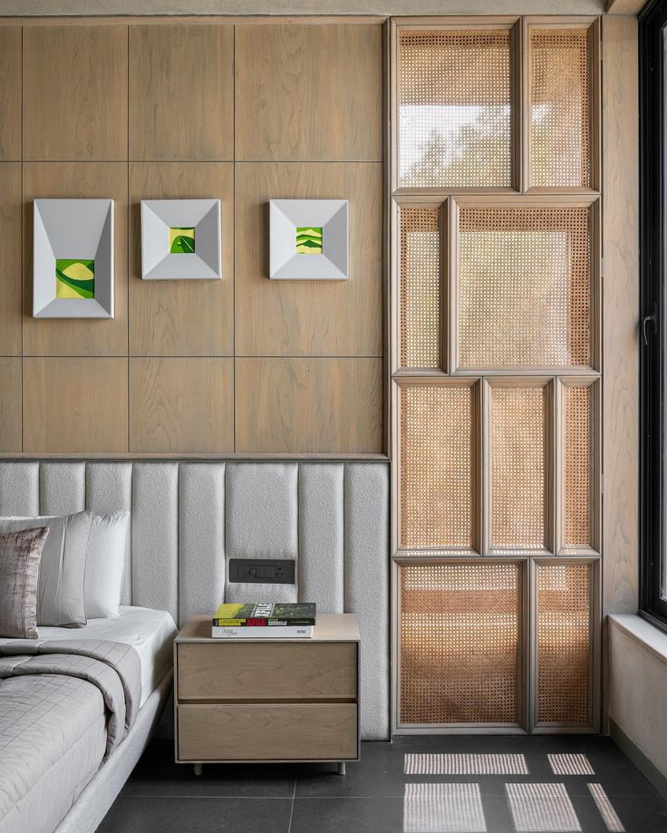 a bed sitting in a bedroom next to a window with wooden panels on the wall