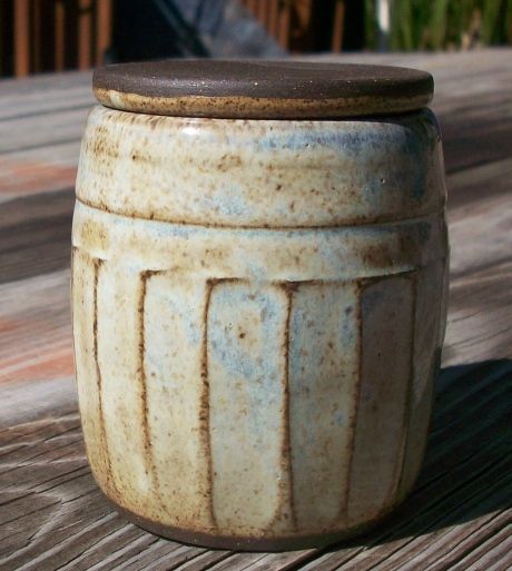 a ceramic jar sitting on top of a wooden table