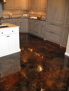 a kitchen with metallic floors and white cabinets