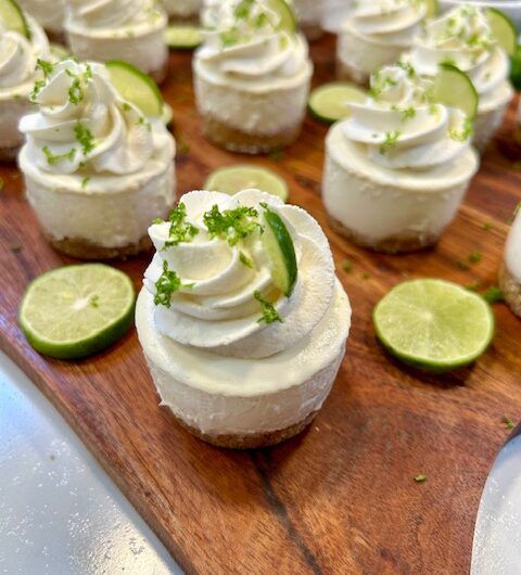 there are many small desserts on the cutting board with cucumbers and lime slices