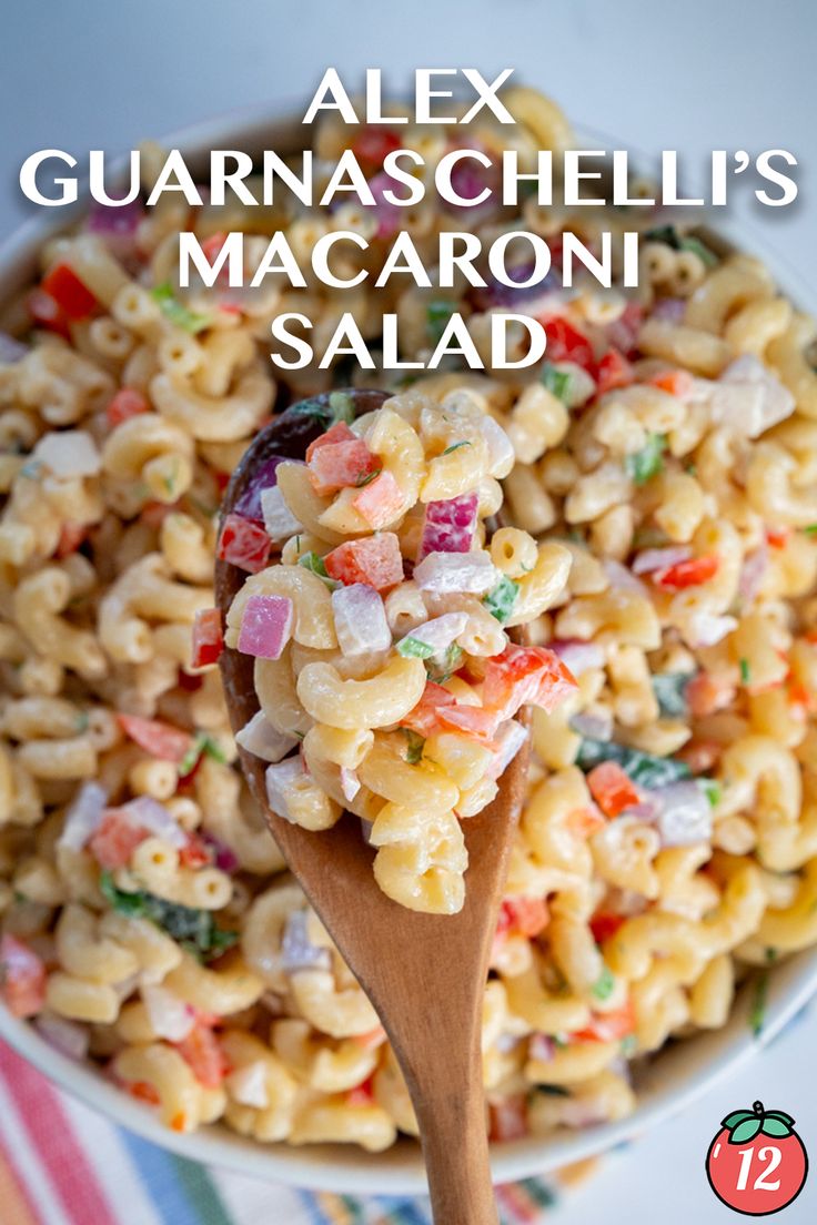 a wooden spoon filled with macaroni salad on top of a striped table cloth