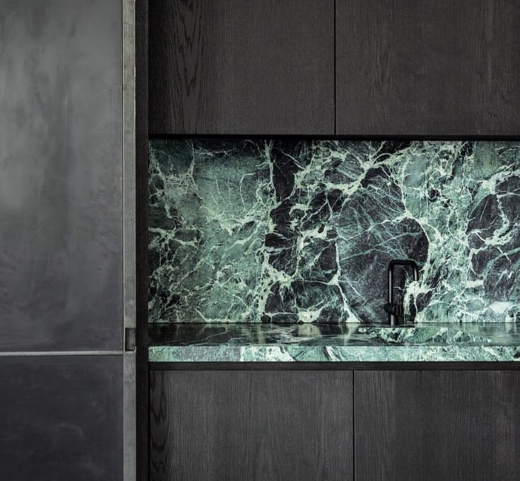 a black cabinet with green marble in the front and side panels on the back wall