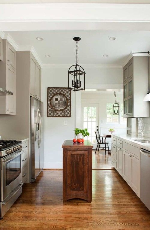 an open kitchen with stainless steel appliances and wood flooring is shown in this image