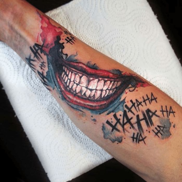 a man's arm with a joker tattoo on it