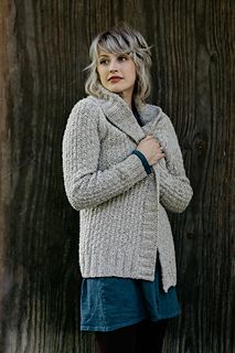 a woman standing in front of a wooden wall with her hands on her hips and looking at the camera