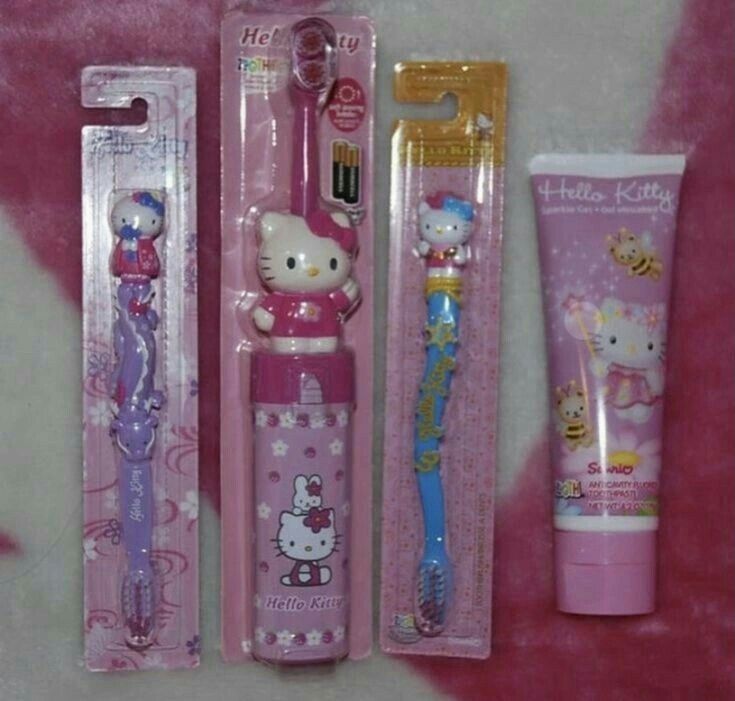 three hello kitty toothbrushes in packaging next to each other on a pink background