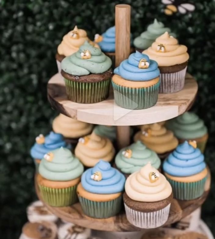 a three tiered cupcake display with blue and yellow frosting on it's sides