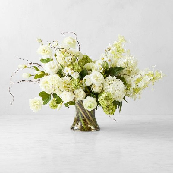 a vase filled with white and green flowers