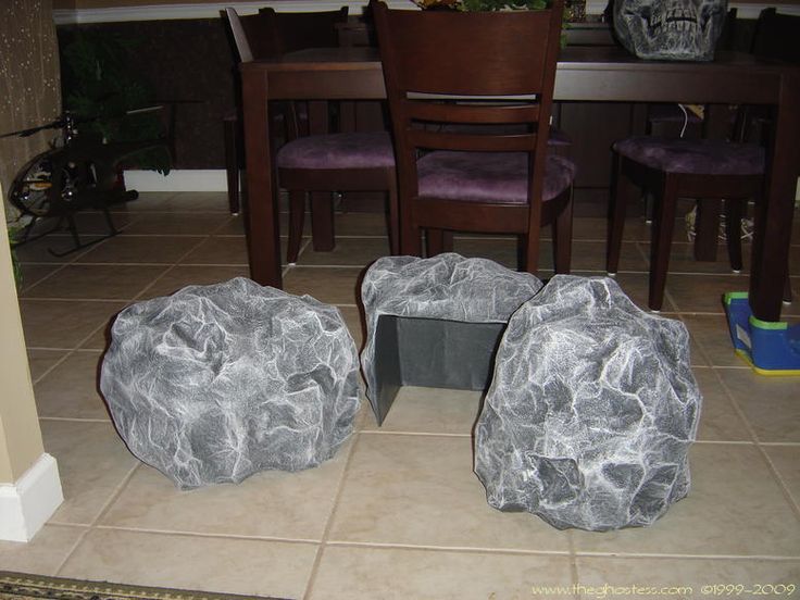 two large rocks sitting on top of a kitchen floor next to a dining room table