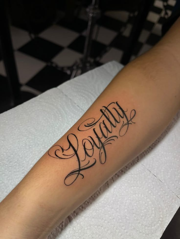 a tattoo with the word joy written in cursive writing on it's arm