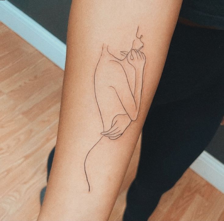 a woman's leg with a tattoo on it that has a line drawing of a hand holding a flower