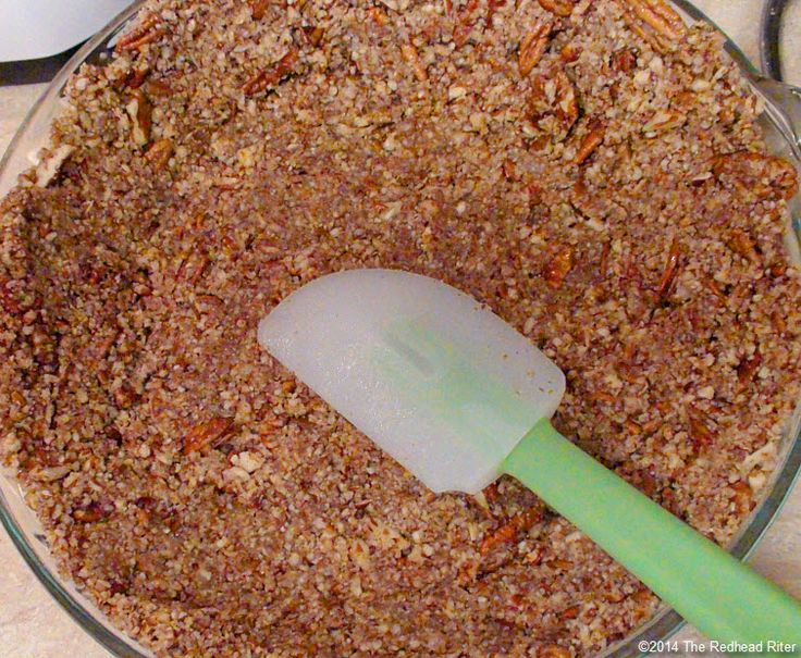 a glass bowl filled with granola and a plastic spatula on top of it